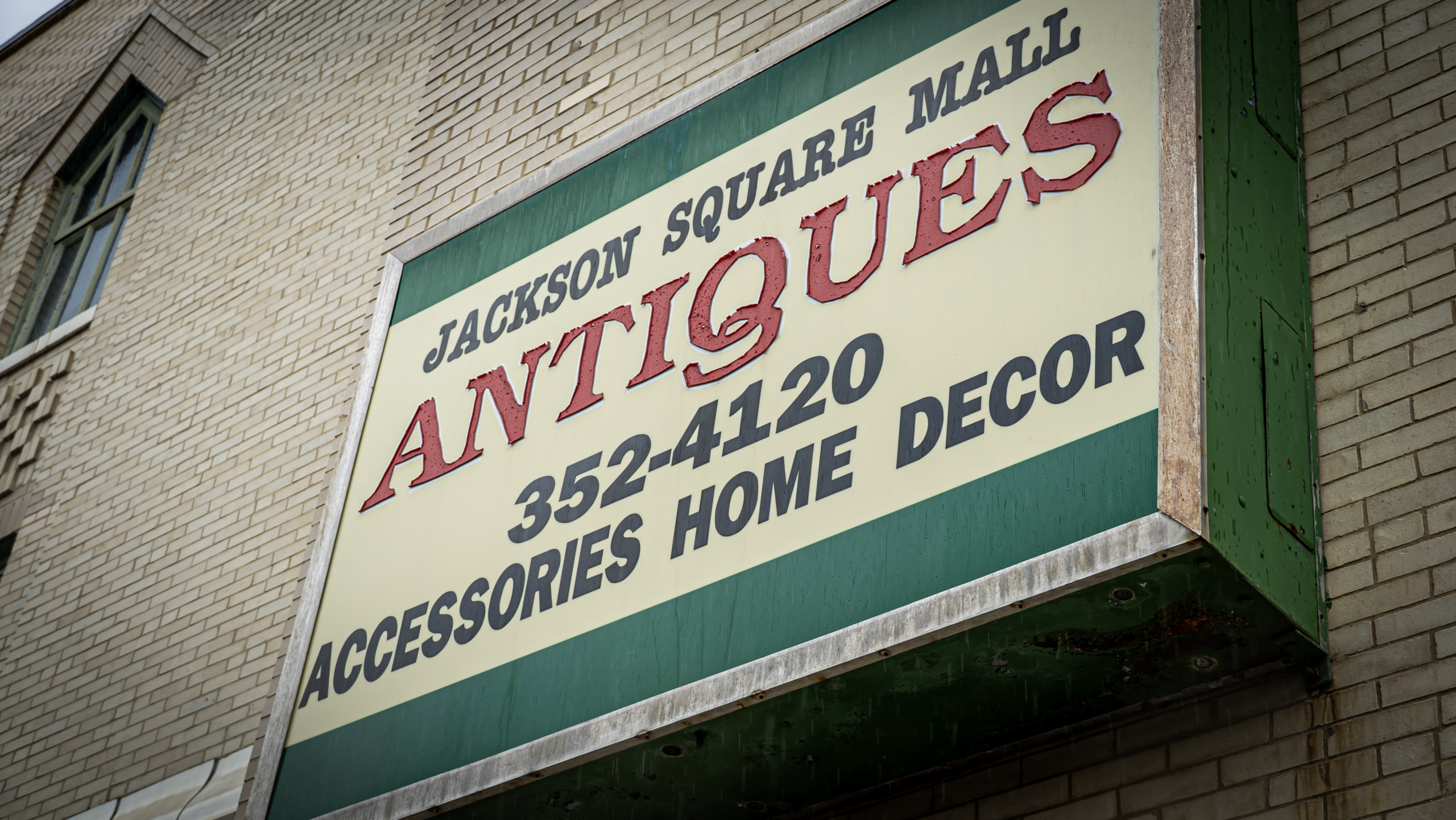 Exterior sign for Jackson Square Mall Antiques advertising accessories, home decor, and the phone number 352-4120.