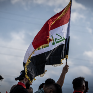 Iraqi fans wave the Iraq flag in the parking lot before the match.