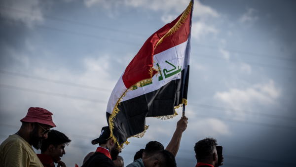 Iraqi fans wave the Iraq flag in the parking lot before the match.